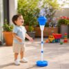 bebe jugando al aire libre en jardín con lanzador de burbujas automático en pedestal.