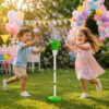 Niños jugando al aire libre en jardín con lanzador de burbujas automático en pedestal
