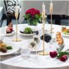 Centro de mesa elegante para cena de gala con candelabros dorados y velas encendidas