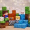 Detalle de bloques pixelados magnéticos con texturas de tierra, roca, agua y césped para construcción creativa.